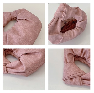 Detail of pink fabric knot bag featuring magnetic closure and burgundy lining texture