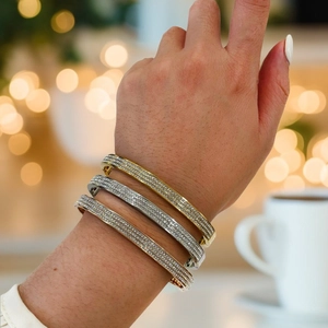Luxe gold silver and rose gold bangles with paved rhinestones on a female wrist