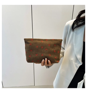 Detail of coffee corduroy tote bag with red strawberry print held by hand