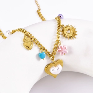 Golden multi-pendant necklace with pearl and heart charms on a white display