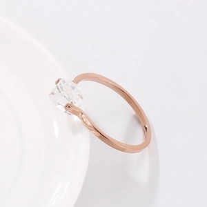 Minimalist rose gold spinning ring with square zircon shown on white ceramic plate