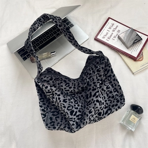 Close-up of leopard print canvas tote bag with wide strap on a minimalist desk setup