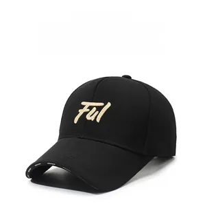 Detail of black baseball cap featuring golden Ful embroidery and white brim printing