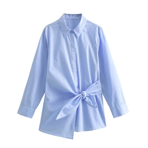 Light blue poplin shirt featuring a waist bow tie and asymmetrical hem in a flat lay view