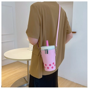 Stylish pink bubble tea cup shaped crossbody bag shown in a lifestyle photography setting