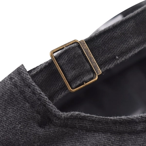Macro view of adjustable bronze metal buckle and textured black washed cotton strap