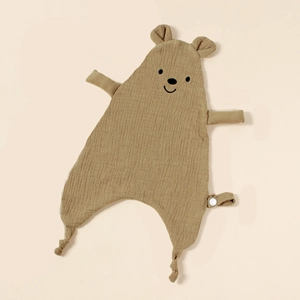 Close-up of brown cotton muslin comforter featuring bear face embroidery and a snap strap