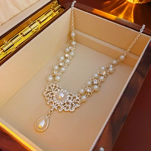 Detail der Tropfenperle mit Strass-Akzenten in einer Vintage-Schmuckschatulle aus Holz