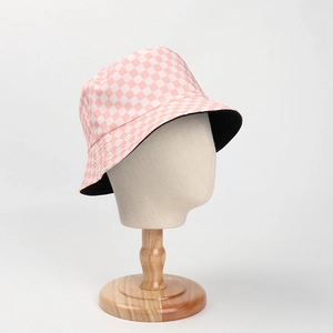 Reversible bucket hat with pink checkered pattern and solid black interior for sun protection