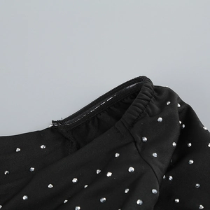 Detailed close-up of rhinestone embellishments on a black French style slim fit dress