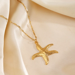 Golden starfish pendant necklace with textured surface on elegant beige silk fabric