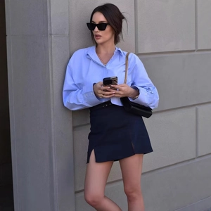 Women's light blue long sleeve cropped shirt with navy split mini skirt outfit