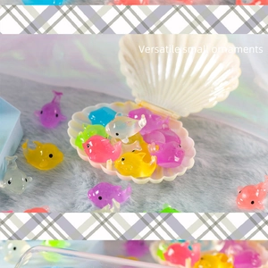 Colorful mini resin dolphins and fish ornaments displayed in a shell-shaped container
