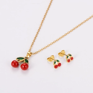 Detail view of the red cherry pendant necklace and stud earrings set in gold finish