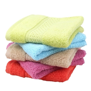 Stack of colorful pure cotton square towels with soft texture and decorative woven stripes