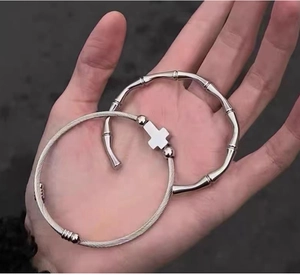 Detail of a titanium steel cross pendant twist bangle and a bamboo joint cuff bracelet
