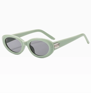 Detail of mint green oval sunglasses with silver metal accents and dark grey lenses