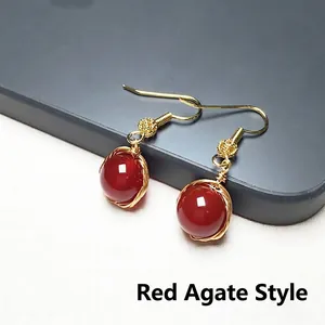 Vue macro détaillée de boucles d'oreilles en agate rouge avec fil d'or et crochets
