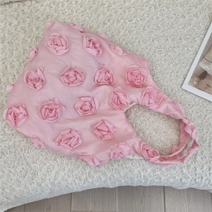 Detail of pink 3D fabric rose flowers on a stylish satin shoulder bag for women