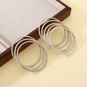 Detailed close-up of 8 minimalist matte silver stainless steel thin bangles on linen