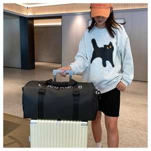 Black fitness bag with luggage strap functionality shown attached to a suitcase handle