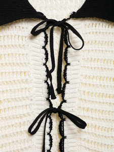 Detail of the knit polo collar with black and white contrast and double bow tie accents
