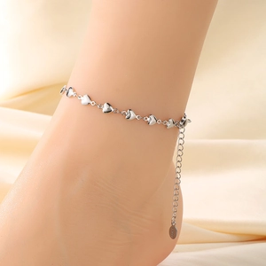 Detail of silver heart-shaped anklet chain with adjustable clasp on ankle