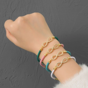 Braided infinity charm bracelets in green, pink, blue, and white with sparkling zircon