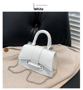 Close-up of white mini handbag with lychee texture and silver beaded chain strap