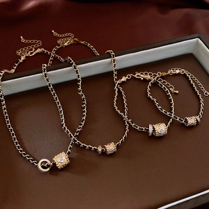 Detail of gold-plated necklace set with black woven chain and zircon flower pendant