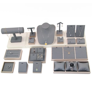 Gray velvet jewelry display set with necklace stands and ring holders on white background