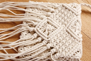 Nahaufnahme der handgewebten Makramee-Tasche aus Baumwolle mit langen Fransen und Textur