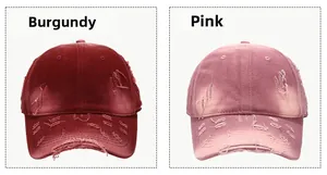 Detail view of burgundy and pink washed cotton baseball caps with distressed ripped edges