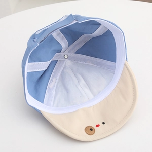 Detail view of baby sun hat showing breathable inner lining and cute bear face design