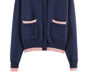 Détail du cardigan en maille bleu marine avec bordure rose, deux poches et boutons noirs