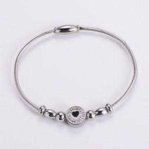 Detail of silver wire cable bracelet with sparkling rhinestone heart and magnetic clasp