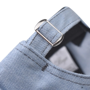 Detail of adjustable silver buckle and denim strap on light blue baseball cap