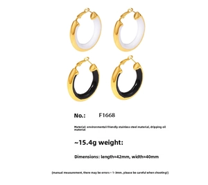 Detail view of large C-shape hoop earrings in black and white enamel with 18K gold plating