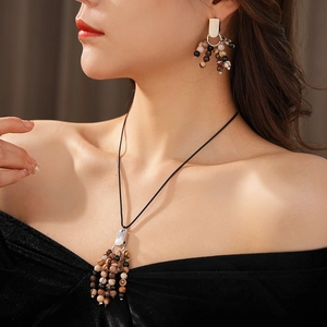Detailed view of bohemian ethnic necklace and earrings with brown natural stone beads
