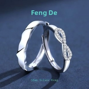 Macro shot of S925 silver infinity couple rings with diamonds on dark blue background