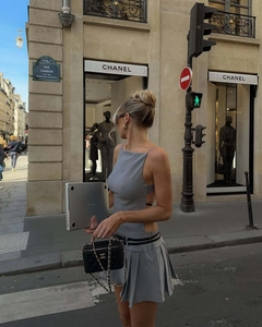 Détail de la robe mini plissée grise dos nu avec découpes latérales et bretelles de style