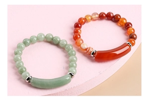 Detailed macro view of green jade and carnelian beaded bracelets with metal spacers