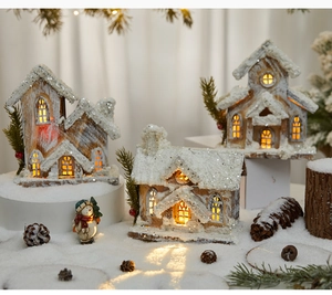 Close-up of three LED lighted wooden Christmas snow houses for festive tabletop decoration