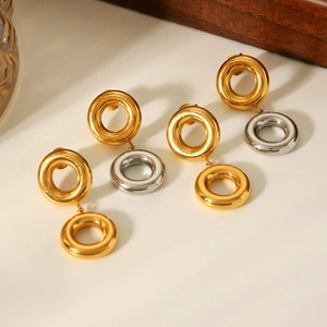 Trois paires de boucles d'oreilles bicolores en or 18K et acier sur support d'affichage