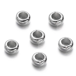 Macro view of six silver ring-shaped metallic spacer beads for DIY jewelry making