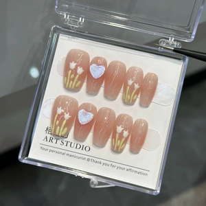 Detailed view of handmade pink press-on nails with tulip art and 3D heart charms