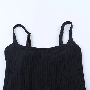 Détail des fines bretelles et du tissu plissé texturé sur une robe longue noire moulante