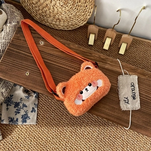 Detail of cute orange plush bear shoulder bag showing soft faux fur and fine embroidery