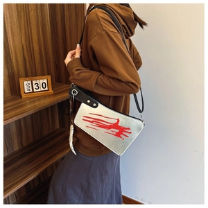 Detail of cleaver-shaped crossbody bag with blood print and silver metallic finish