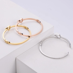 Close-up of heart design steel bangles in gold, rose gold and silver finishes